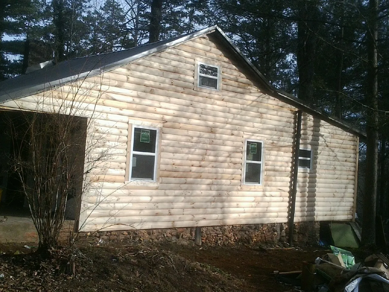 New log siding and dark metal roofing on a gable end in Suquamish